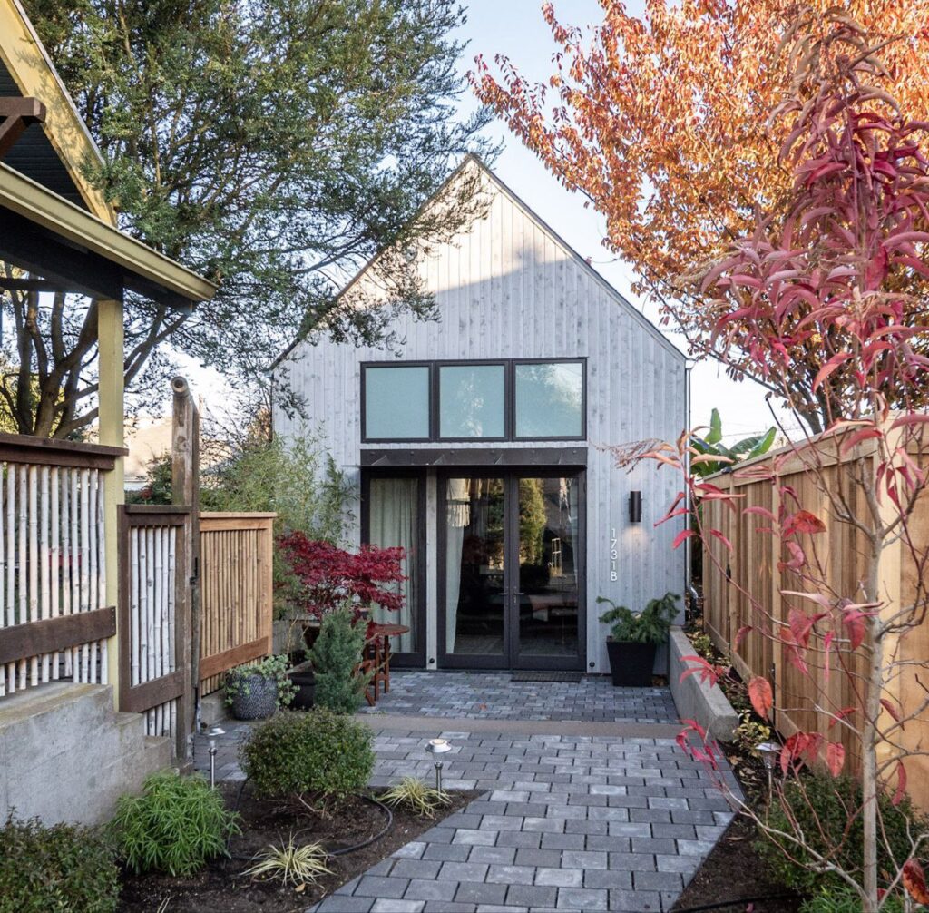 Modern ADU with private walkway and garden trees.